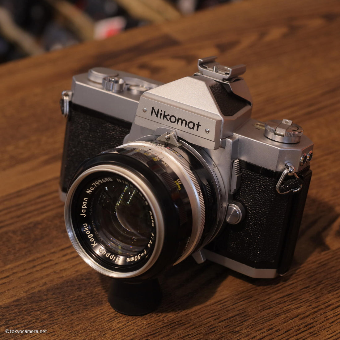 Nikon Nikomat FTN camera with NIKKOR-S Auto 50mm F1.4 lens displayed on wooden surface.