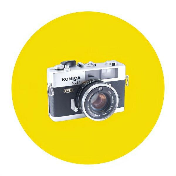 白と黒のKONICA C35コンパクトカメラ、レトロスタイルのデザインです。