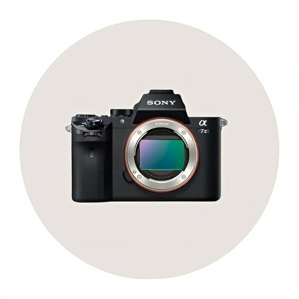 Sony Alpha 7 II digital camera with a sleek black design and open lens, showcased in a circular background.