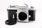 Nikon F film camera body with lens mount and cap, featuring a classic silver and black design.